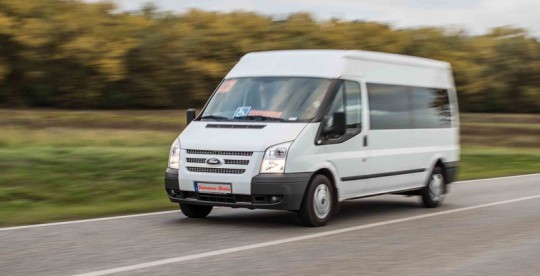 Fahrteam-Berlin Transporter fährt von rechts nach links auf einer Landstraße